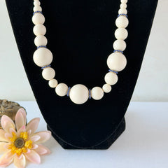 Vintage Banana Republic cream Lucite bead necklace with blue glass bead rondelles and gold‑tone clasp, signed BR.