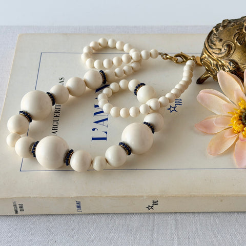 Vintage Banana Republic cream Lucite bead necklace with blue glass bead rondelles and gold‑tone clasp, signed BR.