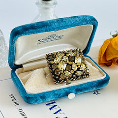 A vintage Barclay gold‑tone brooch set with jonquil rhinestones in mixed cuts, shown from various angles to display its shape, details, and condition.