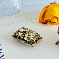 A vintage Barclay gold‑tone brooch set with jonquil rhinestones in mixed cuts, shown from various angles to display its shape, details, and condition.