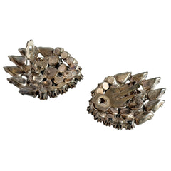 Vintage clear rhinestone clip‑on earrings with teardrop and chaton stones in a mid‑century silver tone fan‑cluster design.
