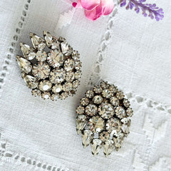 Vintage clear rhinestone clip‑on earrings with teardrop and chaton stones in a mid‑century silver tone fan‑cluster design.