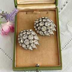 Vintage clear rhinestone clip‑on earrings with teardrop and chaton stones in a mid‑century silver tone fan‑cluster design.