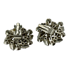 Vintage 1950s silver-tone clip-on earrings with black diamond and clear rhinestones in a radiant pinwheel design; unsigned but crafted with rivet and swedge construction typical of Beau Jewels or Judy Lee, approx. 1¼" diameter, in very good vintage condition with secure clips and brilliant sparkle.