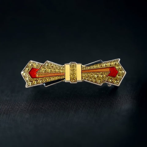 Vintage Art Deco style bow brooch with geometric enamel and resin design in black, gold, red, and white on silver tone base.
