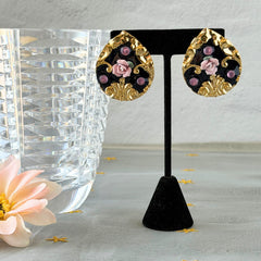 Vintage 1980s teardrop post earrings with 3D pink polymer clay rose, black enamel base, and gold tone pressed metal scrollwork on original card.