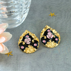 Vintage 1980s teardrop post earrings with 3D pink polymer clay rose, black enamel base, and gold tone pressed metal scrollwork on original card.