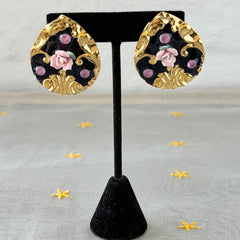 Vintage 1980s teardrop post earrings with 3D pink polymer clay rose, black enamel base, and gold tone pressed metal scrollwork on original card.