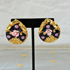 Vintage 1980s teardrop post earrings with 3D pink polymer clay rose, black enamel base, and gold tone pressed metal scrollwork on original card.