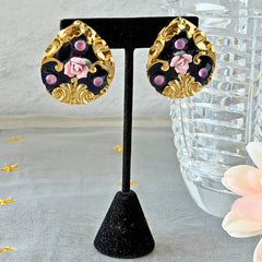 Vintage 1980s teardrop post earrings with 3D pink polymer clay rose, black enamel base, and gold tone pressed metal scrollwork on original card.