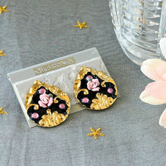 Vintage 1980s teardrop post earrings with 3D pink polymer clay rose, black enamel base, and gold tone pressed metal scrollwork on original card.