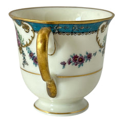 Vintage Black Knight Hohenberg Bavaria porcelain demi-tasse teacup in Monceau pattern; white base with multicolored floral design, teal and gold scrollwork near rim, and gold-trimmed handle and pedestal base.