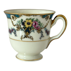 Vintage Black Knight Hohenberg Bavaria porcelain demi-tasse teacup in Monceau pattern; white base with multicolored floral design, teal and gold scrollwork near rim, and gold-trimmed handle and pedestal base.