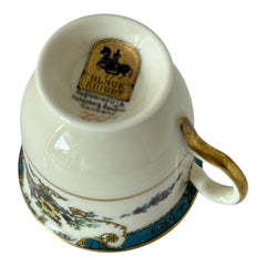 Vintage Black Knight Hohenberg Bavaria porcelain demi-tasse teacup in Monceau pattern; white base with multicolored floral design, teal and gold scrollwork near rim, and gold-trimmed handle and pedestal base.