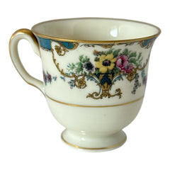 Vintage Black Knight Hohenberg Bavaria porcelain demi-tasse teacup in Monceau pattern; white base with multicolored floral design, teal and gold scrollwork near rim, and gold-trimmed handle and pedestal base.