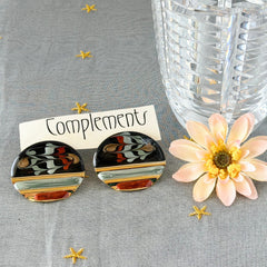 Vintage 1980s black, green, and rust enamel geometric gold‑tone circle post earrings on original Complements card, shown on grey fabric background.
