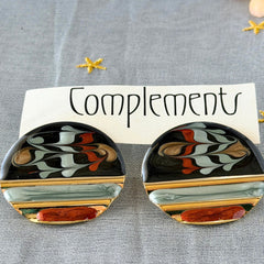 Vintage 1980s black, green, and rust enamel geometric gold‑tone circle post earrings on original Complements card, shown on grey fabric background.
