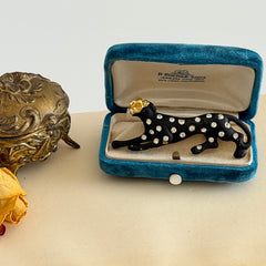 Black matte enamel panther brooch with clear rhinestones and gold tone accents, vintage 1990s animal jewelry.