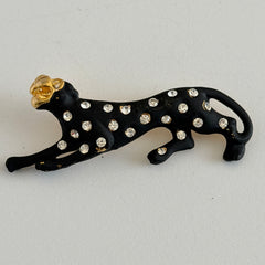 Black matte enamel panther brooch with clear rhinestones and gold tone accents, vintage 1990s animal jewelry.