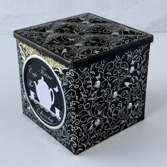 French black matelassé metal tea cube tin with silver accents and a pink teapot motif by Moldeo