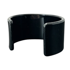 A vintage black plastic cuff bracelet featuring a sleek design with clear rhinestones arranged in small floral patterns. The bracelet, likely from the 2000s, is shown in very good condition with minimal surface scratching, adding timeless elegance and eco-conscious charm to any outfit.