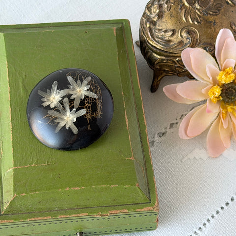 Vintage round brooch with real dried flowers encased in clear resin on a lacquered wood base, shown from multiple angles.