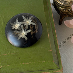 Vintage round brooch with real dried flowers encased in clear resin on a lacquered wood base, shown from multiple angles.