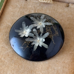 Vintage round brooch with real dried flowers encased in clear resin on a lacquered wood base, shown from multiple angles.