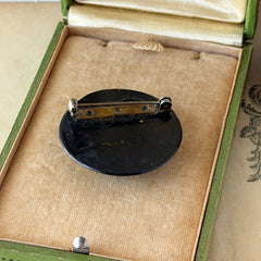 Vintage round brooch with real dried flowers encased in clear resin on a lacquered wood base, shown from multiple angles.