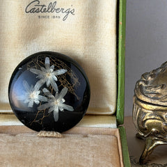 Vintage round brooch with real dried flowers encased in clear resin on a lacquered wood base, shown from multiple angles.