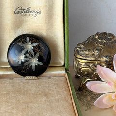Vintage round brooch with real dried flowers encased in clear resin on a lacquered wood base, shown from multiple angles.