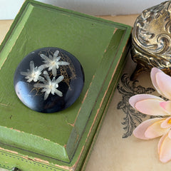 Vintage round brooch with real dried flowers encased in clear resin on a lacquered wood base, shown from multiple angles.