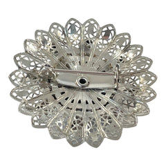 Vintage silver‑tone filigree brooch with sapphire blue and clear rhinestones in a floral design.