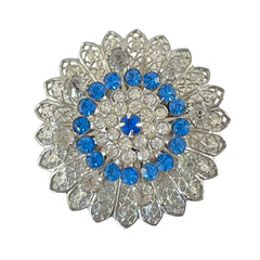 Vintage silver‑tone filigree brooch with sapphire blue and clear rhinestones in a floral design.