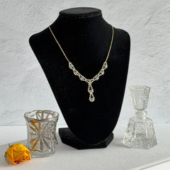 Vintage silver‑tone necklace with a delicate blue and clear rhinestone drop pendant on an adjustable chain.