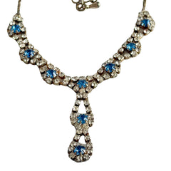 Vintage silver‑tone necklace with a delicate blue and clear rhinestone drop pendant on an adjustable chain.