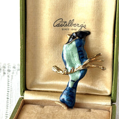 Vintage blue and green enamel gold‑tone bird brooch perched on a branch, shown from multiple angles.