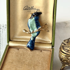 Vintage blue and green enamel gold‑tone bird brooch perched on a branch, shown from multiple angles.