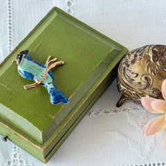 Vintage blue and green enamel gold‑tone bird brooch perched on a branch, shown from multiple angles.