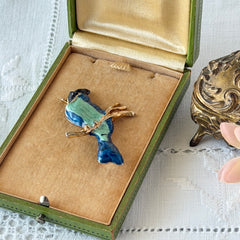 Vintage blue and green enamel gold‑tone bird brooch perched on a branch, shown from multiple angles.