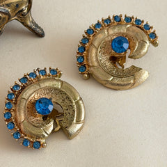 Vintage 1980s textured gold tone spiral clip-on earrings with blue rhinestones.