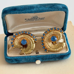 Vintage 1980s textured gold tone spiral clip-on earrings with blue rhinestones.