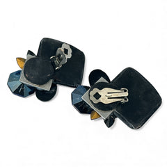 Vintage 1980s statement clip-on earrings with capri blue vitrail and black crystals in geometric cuts, set on a black leather square base.