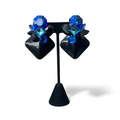 Vintage 1980s statement clip-on earrings with capri blue vitrail and black crystals in geometric cuts, set on a black leather square base.