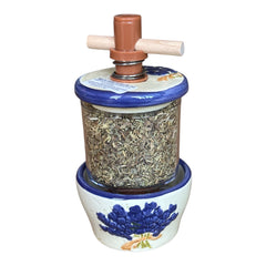 Provence ceramic herb mill with hand-painted blue lavender sprigs and green leaves on a cream base, featuring a glass chamber filled with dried herbs and a wooden crossbar handle for grinding.