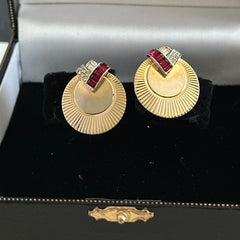 Pair of vintage Marcel Boucher gold‑tone disk clip‑on earrings with ruby‑red baguette rhinestones and clear rhinestone accents.