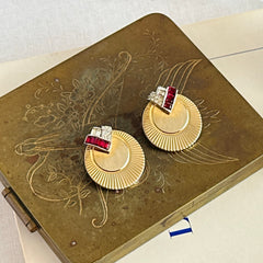 Pair of vintage Marcel Boucher gold‑tone disk clip‑on earrings with ruby‑red baguette rhinestones and clear rhinestone accents.