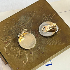 Pair of vintage Marcel Boucher gold‑tone disk clip‑on earrings with ruby‑red baguette rhinestones and clear rhinestone accents.