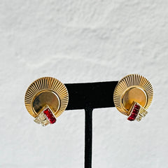 Pair of vintage Marcel Boucher gold‑tone disk clip‑on earrings with ruby‑red baguette rhinestones and clear rhinestone accents.