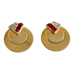 Pair of vintage Marcel Boucher gold‑tone disk clip‑on earrings with ruby‑red baguette rhinestones and clear rhinestone accents.